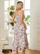 Woman wearing a floral dress standing in a bright room with large windows.