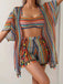 Woman wearing a colorful striped outfit with a matching jacket on a plain background
