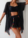 Black outfit with colorful tassels on a plain background