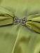 Green fabric with a butterfly-shaped brooch