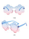 Occhiali da sole a forma di fiore con lenti sfumate dal blu al rosa e montatura blu trasparente, perfetti per un look estivo vivace.