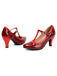 Pair of red high-heeled shoes with a strap on a white background