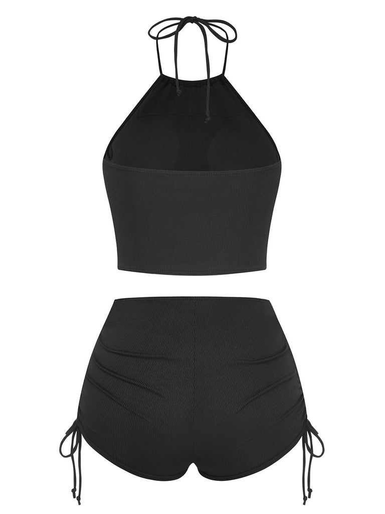 Black two-piece swimsuit with halter top and shorts on a white background