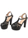 A pair of timeless black high-heeled sandals with an adjustable buckle strap and a thick platform sole.