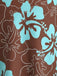 Macro shot of the fabric detail showcasing the turquoise hibiscus flowers and white line art foliage on a chocolate brown background.