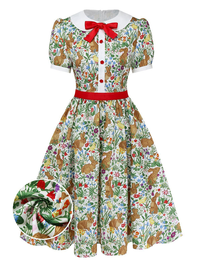 A vintage-inspired short-sleeve A-line dress featuring a whimsical bunny and wildflower print, a white Peter Pan collar, and a red bow accent.
